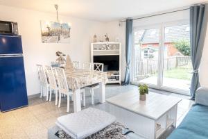 a kitchen and living room with a dining room table and a table at Ferienhaus Ostsee in Pruchten