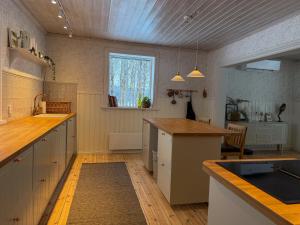a large kitchen with a counter and a window at Secluded Lakehouse in Falun +8 photos