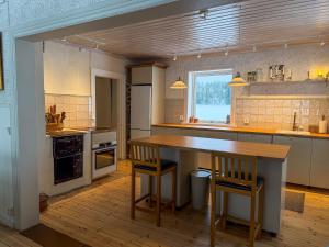 a kitchen with a wooden table and two chairs at Secluded Lakehouse in Falun