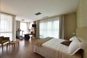 una camera da letto con un letto grande e un soggiorno di Tatì Hotel a Lugo