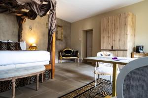 a room with a bed and a table and chairs at Le Clos Violette et Le 11 D'Aglaé - Appart' Hôtel de Charme Design de Luxe in L'Isle-sur-la-Sorgue