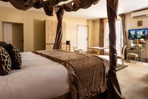 a bedroom with a bed with a canopy at Le Clos Violette et Le 11 D'Aglaé - Appart' Hôtel de Charme Design de Luxe in L'Isle-sur-la-Sorgue