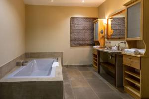 a bathroom with a large tub and a sink at Le Clos Violette et Le 11 D'Aglaé - Appart' Hôtel de Charme Design de Luxe in L'Isle-sur-la-Sorgue