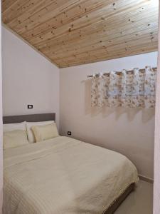 a bedroom with a bed and a wooden ceiling at Guest House Vajzë S,Kasaj in Vlorë