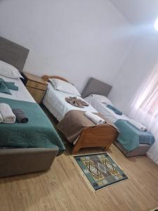 two twin beds in a bedroom with a rug at Guest House Vajzë S,Kasaj in Vlorë