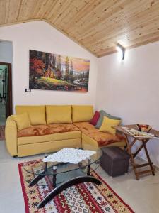 a living room with a couch and a painting on the wall at Guest House Vajzë S,Kasaj in Vlorë +3 photos