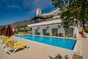 ein Hotelpool mit Liegestühlen und ein Gebäude in der Unterkunft Sunshine Holiday Resort in Oludeniz