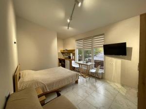 a bedroom with a bed and a desk and a television at У Оксани in Solochyn
