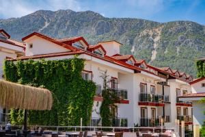 Ein mit Efeu bewachsenes Gebäude vor dem Hintergrund der Berge in der Unterkunft Sunshine Holiday Resort in Oludeniz