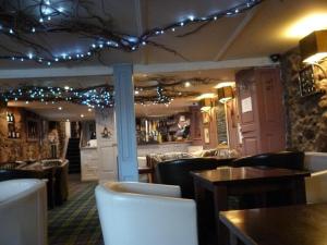 a restaurant with chairs and tables and lights on the ceiling at No 1 Hotel in Wooler +9 photos