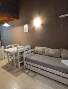a room with a table and a bed and a table and chairs at Kumen Apart de Playa in San Bernardo