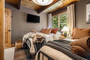 a bedroom with two beds and a tv on the wall at Starlight Chalet Lake Tahoe in Carnelian Bay