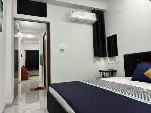 a bedroom with a bed with a blue comforter at MP Homestay in Godarpura