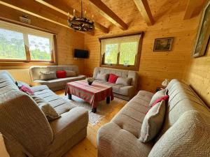 a living room with two couches and a table at Chata RAIKA in Čierny Potok