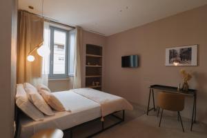 a bedroom with a bed and a desk and a window at Camillò Guest House in Ivrea