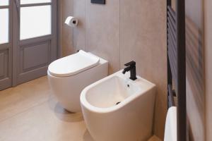 a bathroom with a white toilet and a sink at Camillò Guest House in Ivrea