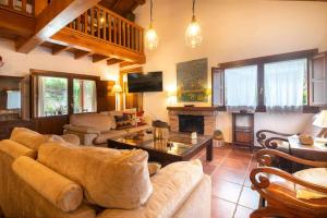 a living room with a couch and a fireplace at Villa El Ñeru – Bufones de Pría, Llanes in Cuerres
