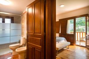 a bathroom with a toilet and a bed with a window at Villa El Ñeru – Bufones de Pría, Llanes in Cuerres +42 photos