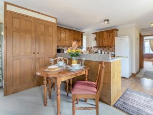 a kitchen with a wooden table and wooden cabinets at 1 Bed in Helston oc-bbird in Saint Martin +17 photos