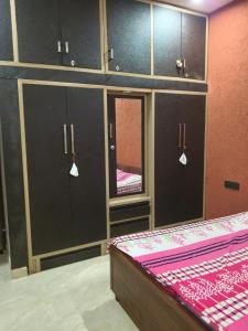a room with a bed and cabinets and a mirror at Sahib ka Ghar in Kharar