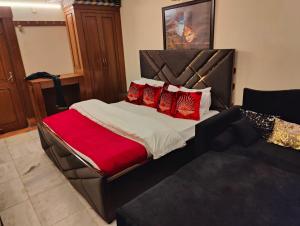 a bedroom with a large bed with red pillows at Shri Rang Ji Palace in Vrindāvan