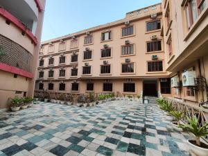 an empty courtyard of a large building with plants at Shri Rang Ji Palace in Vrindāvan