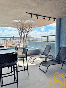 a patio with chairs and a table and a pool at Ble Camboinha 101 in Camalaú
