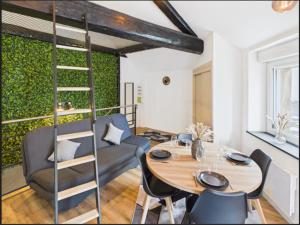 a dining room with a table and a green wall at L'escapade Vosgienne, Cinéma, Balnéo in Remiremont