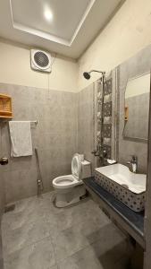 a bathroom with a toilet and a sink at Gulberg Inn Hotel Lahore in Lahore