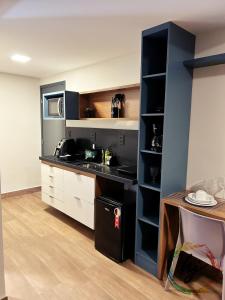 a kitchen with a black counter and a sink at Mares Cabo Branco 209 in Tambaú