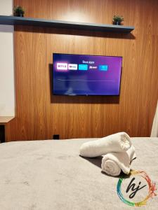 a tv on a wall with a towel on a bed at Mares Cabo Branco 209 in Tambaú +19 photos