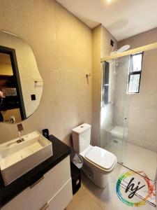 a bathroom with a toilet and a sink and a shower at Mares Cabo Branco 209 in Tambaú