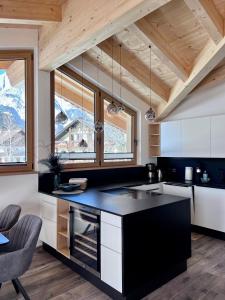a kitchen with a black counter top and some windows at Chalet Hirschegg - modernes Dorfchalet mit Panorama in Leutasch