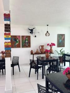 a dining room with black tables and chairs at Pousada Flor De Prado in Prado