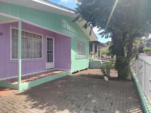 a house with a purple and green exterior at Um lar acolhedor in Pato Branco