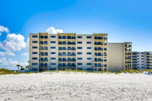 a building on the beach next to the beach at ‘Emerald Dreams’ Beach & Lakefront West PCB Condo in Panama City Beach