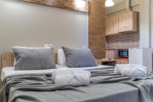a large bed with grey sheets and pillows at Iliovasilema Hotel in Mytikas