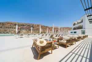 a row of chairs and tables on the roof of a building at Amadores View - Adults only in Mogán