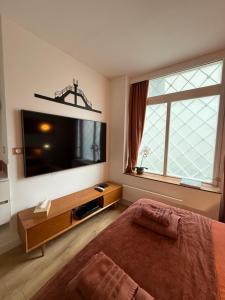 a bedroom with a large flat screen tv and a bed at Le Plongeoir, intra-muros in Saint Malo