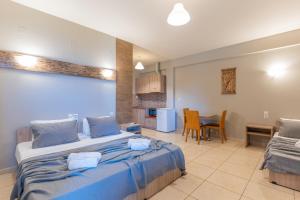 a bedroom with a large bed and a kitchen at Iliovasilema Hotel in Mytikas