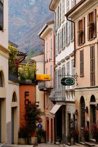 a group of buildings on a street with mountains in the background at Piazza del Lago Suites - Menaggio in Menaggio