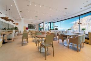 a restaurant with tables and chairs and large windows at Amadores View - Adults only in Mogán