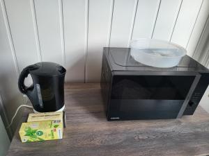 a microwave sitting on a table with a cup and a mug at Hotel Schlaun in Nordkirchen