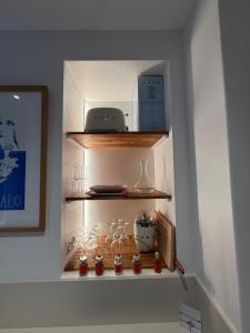 a shelf with wine glasses and other items on it at Le Plongeoir, intra-muros in Saint Malo