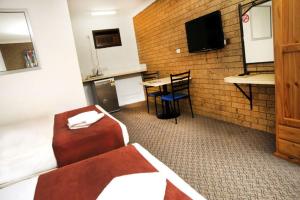 a hotel room with a couch and a television at Annalee Motel Beaudesert in Beaudesert
