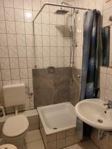 a bathroom with a toilet a sink and a shower at Hotel Schlaun in Nordkirchen