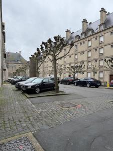 a parking lot with cars parked in front of a building at Le Plongeoir, intra-muros in Saint Malo
