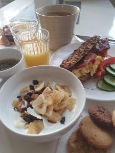 a table with plates of food and a bowl of food at Hotel Bishops Arms Strängnäs in Strängnäs +28 photos