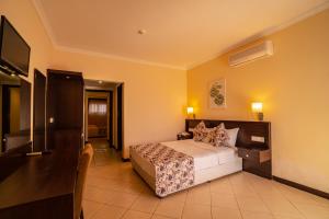 ein Schlafzimmer mit Bett und Flachbildfernseher in der Unterkunft Sunshine Holiday Resort in Oludeniz