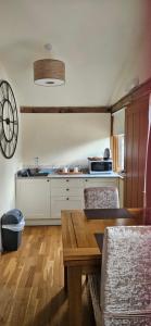a kitchen with a table and chairs in a room at The Chalet in Oxford
